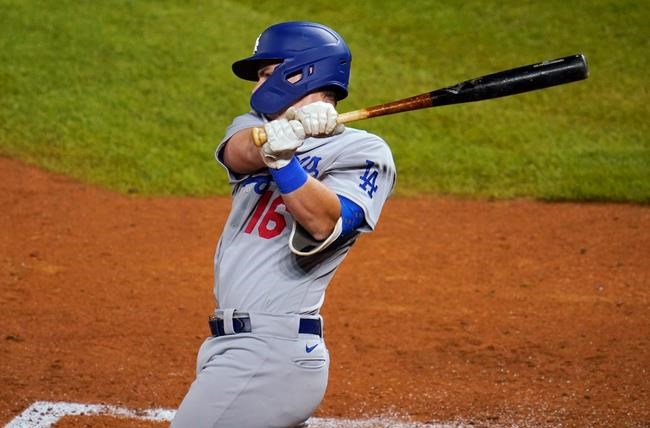 Los Angeles Dodgers' Will Smith follows through on a two-run double off Colorado Rockies relief pitcher Carlos Estevez during the seventh inning of a baseball game Thursday, Sept. 17, 2020, in Denver. (AP Photo/David Zalubowski)