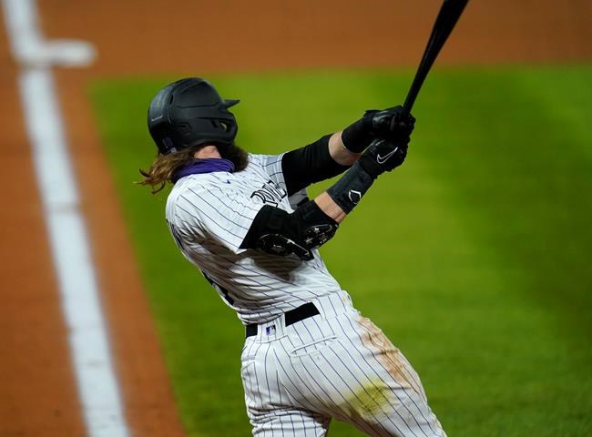 Colorado Rockies' Charlie Blackmon follows through on a grand slam off Los Angeles Angels relief pitcher Jose Quijada during the ninth inning of a baseball game Friday, Sept. 11, 2020, in Denver. The Rockies won 8-4. (AP Photo/David Zalubowski)