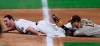 San Diego Padres third baseman Manny Machado, right, holds up his glove to show that he tagged out Colorado Rockies' Daniel Murphy as he tries to advacnce from first to third base on a single hit by Ryan McMahon in the sixth inning of a baseball game Friday, July 31, 2020, in Denver. (AP Photo/David Zalubowski)