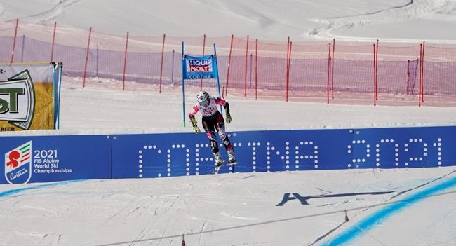 FILE - In this Jan. 20, 2019 file photo, Liechtenstein's Tina Weirather speeds down the course as a banner advertising the ski world championships in Cortina d'Ampezzo is seen in background, during an alpine ski, women's World Cup super-G in Cortina D'Ampezzo, Italy. The natural beauty of Cortina will be of special importance at the alpine ski World championships, with organizers hoping that the images from the slopes beamed around the globe to TV viewers will make up for the lack of fans amid the coronavirus pandemic. (AP Photo/Giovanni Auletta, File)