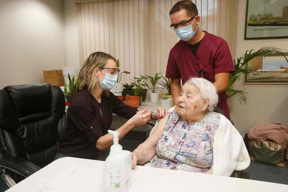 CP
Dr. Joss Reimer, medical lead on the Vaccine Implementation Task Force, injects Taisa Koberstein with her first dose of the COVID-19 vaccine as nurse Jervine Ramos assists at Meadowood Manor in Winnipeg. (John Woods / Canadian Press files)