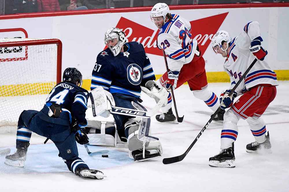 THE CANADIAN PRESS
Winnipeg Jets' Josh Morrissey (44) stops the puck from getting past goaltender Connor Hellebuyck (37) on a shot by New York Rangers' Jacob Trouba (8) during the second period of NHL action in Winnipeg, Sunday, March 6, 2022. (Fred Greenslade / The Canadian Press)