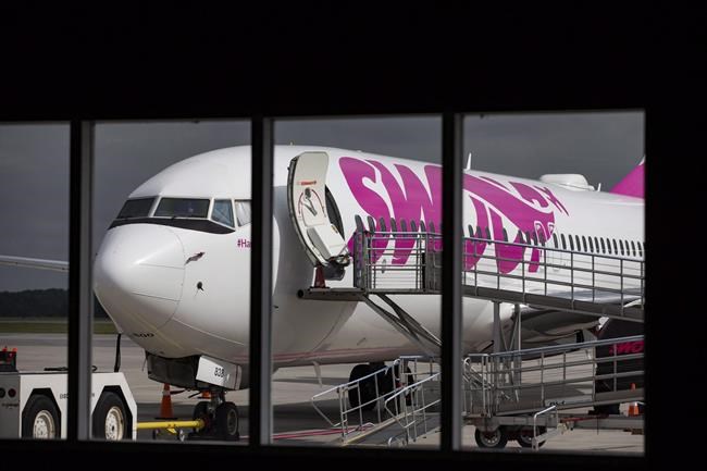 Swoop Airlines Boeing 737 on display during their media event, Tuesday, June 19, 2018 at John C. Munro International Airport in Hamilton, Ont. Budget airline Swoop is adding flights to three Atlantic Canadian cities from Hamilton this summer. The expansion by the low-cost subsidiary of WestJet Airlines Ltd. marks the parent company's latest move to challenge Air Canada's dominance in the Maritimes. THE CANADIAN PRESS/Tara Walton