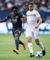 Vancouver Whitecaps' Alphonso Davies, left, and Los Angeles FC's Dejan Jakovic vie for the ball during second half MLS soccer action in Vancouver, B.C., on Friday April 13, 2018. Los Angeles FC has re-signed Canadian international Dejan Jakovic and fellow defender Jordan Harvey. THE CANADIAN PRESS/Darryl Dyck