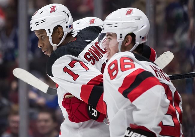 New Jersey Devils' Wayne Simmonds (17) and Jack Hughes (86) celebrate Simmonds' goal during first period NHL hockey action against the Vancouver Canucks, in Vancouver, Sunday, Nov. 10, 2019. While Wayne Simmonds calls the Akim Aliu-Bill Peters story