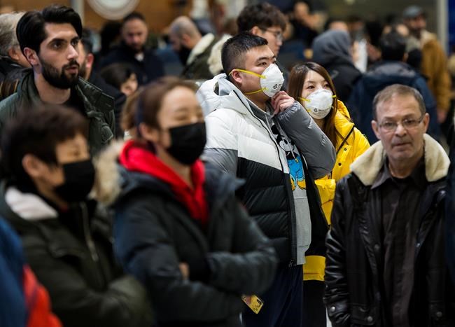 People wear masks as they wait for the arrivals at the International terminal at Toronto Pearson International Airport in Toronto on Saturday, January 25, 2020. Leaders of Toronto's Chinese community said Wednesday the racist attitudes that led to widespread discrimination against Chinese Canadians during the SARS epidemic are threatening to resurface during the current outbreak of a new coronavirus.THE CANADIAN PRESS/Nathan Denette