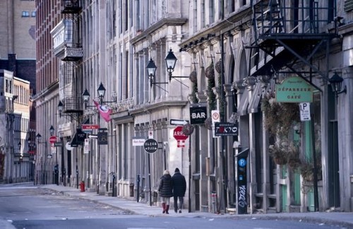 A couple walks along a deserted street in Old Montreal on Tuesday, March 31, 2020. As Canadians face the possibility of being alone with their significant other for the foreseeable future, some say marital discord is more likely than the kind of intimacy that would lead to a baby boom nine months from now. THE CANADIAN PRESS/Paul Chiasson