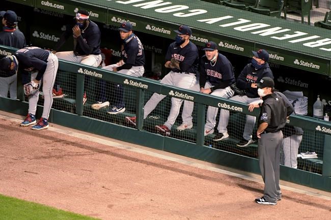Cleveland Indians wait out a brief suspension of play during the fifth inning after a drone landed in center field, before taking off and flying out of the ballpark during a baseball game between the Chicago Cubs and the Indians on Wednesday, Sept. 16, 2020, in Chicago. (AP Photo/Mark Black)