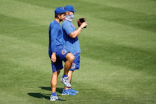 Chicago Cubs first baseman Anthony Rizzo, left, stands next to manager David Ross, right, during baseball practice at Wrigley Field, Sunday, July 5, 2020, in Chicago. (AP Photo/Kamil Krzaczynski)