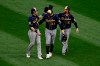 Milwaukee Brewers outfielders Christian Yelich, Avisail Garcia and Ben Gamel, from left, celebrate after the Brewers defeated the Chicago Cubs 6-5 in 10 innings in a baseball game Saturday, Aug. 15, 2020, in Chicago. (AP Photo/Paul Beaty)
