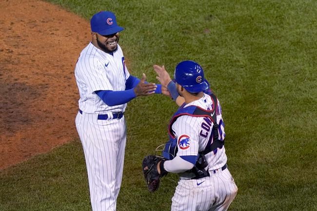 Chicago Cubs relief pitcher Jeremy Jeffress, left, and catcher Willson Contreras celebrate the team's 8-5 win over the Cincinnati Reds in a baseball game, early Friday, Sept. 11, 2020, in Chicago. (AP Photo/Charles Rex Arbogast)