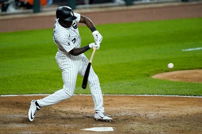 Chicago White Sox's Tim Anderson swings into an RBI-double off Minnesota Twins relief pitcher Taylor Rogers during the eighth inning of a baseball game Monday, Sept. 14, 2020, in Chicago. Luis Robert scored on the play. (AP Photo/Charles Rex Arbogast)