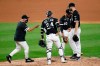 Chicago White Sox manager Ricky Renteria, left, goes to the mound to relieve starting pitcher Lucas Giolito, right, as Yasmani Grandal and Yoan Moncada watch during the fourth inning of baseball game against the Minnesota Twins, Friday, July 24, 2020, in Chicago. (AP Photo/Charles Rex Arbogast)