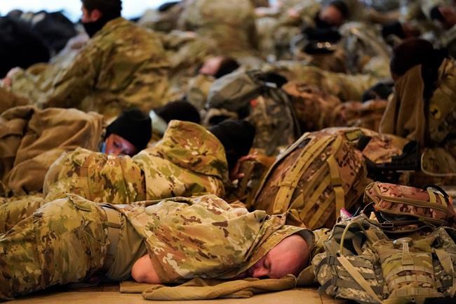 Troops rest as they hold inside the Capitol Visitor's Center to reinforce security at the Capitol in Washington, Wednesday, Jan. 13, 2021. The House of Representatives is pursuing an article of impeachment against President Donald Trump for his role in inciting an angry mob to storm the Capitol last week.. (AP Photo/Alex Brandon)