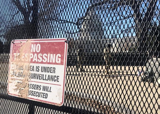 Members of the National Guard stand inside anti-scaling fencing that surrounds the Capitol complex, Sunday, Jan. 10, 2021, in Washington. (AP Photo/Alan Fram)