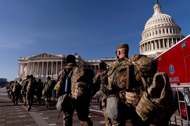 Members of the National Guard walk past the Dome of the Capitol Building on Capitol Hill in Washington, Thursday, Jan. 14, 2021. (AP Photo/Andrew Harnik)