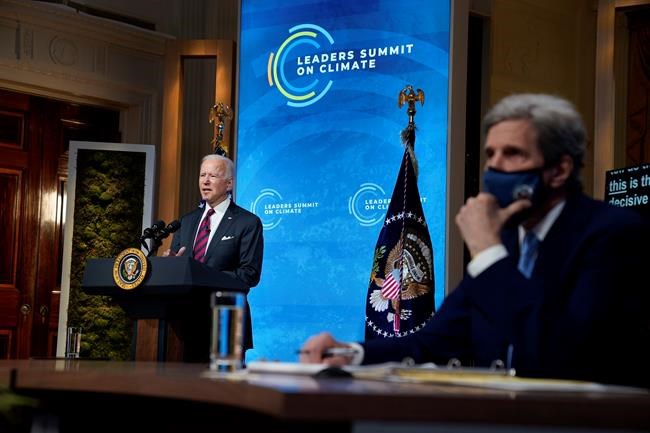 President Joe Biden speaks to the virtual Leaders Summit on Climate, from the East Room of the White House, Thursday, April 22, 2021, in Washington, as Special Presidential Envoy for Climate John Kerry, looks on. (AP Photo/Evan Vucci)