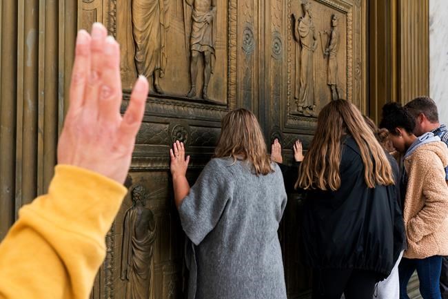 People pray to Jesus at the door of the Supreme Court in support of Supreme Court nominee Amy Coney Barrett, Monday, Oct. 26, 2020, outside the Supreme Court on Capitol Hill in Washington. (AP Photo/Jacquelyn Martin)