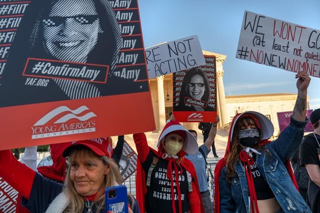 Jennifer Friend of Gainesville, Fla., left, rallies in favor of the nomination of Amy Coney Barrett to the Supreme Court, next to Sydney Hopfer, and Deidra Hubay, right, both of Pittsburgh, who oppose it, outside the Supreme Court, Monday, Oct. 26, 2020, on Capitol Hill in Washington. (AP Photo/Jacquelyn Martin)