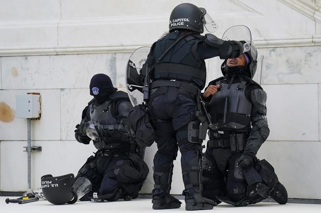 A police officer has eyes flushed with water after a confrontation with demonstrators, Wednesday, Jan. 6, 2021, at the Capitol in Washington. As Congress prepares to affirm President-elect Joe Biden's victory, thousands of people have gathered to show their support for President Donald Trump and his claims of election fraud.(AP Photo/John Minchillo)