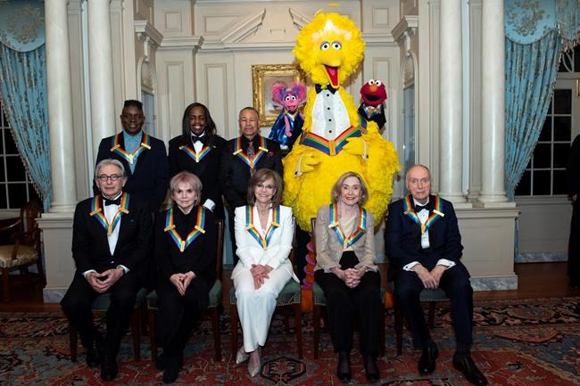 Front row from left, 2019 Kennedy Center Honorees Michael Tilson Thomas, Linda Ronstadt, Sally Field, Joan Ganz Cooney, and Lloyd Morrisett, back row from left, Philip Bailey, Verdine White, Ralph Johnson, and characters from