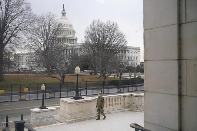 With the U.S. Capitol Building in view, a member of the military stands guard outside Russell Senate Office Building on Capitol Hill in Washington, Friday, Jan. 8, 2021, in response to supporters of President Donald Trump who stormed the Capitol. (AP Photo/Patrick Semansky)