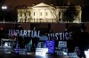 Protesters display signs and sing in front of the White House in Washington, Tuesday, Jan. 14, 2020. (AP Photo/Steve Helber)
