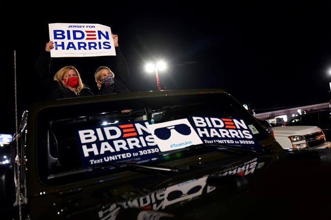 People arrive for an election night rally for Democratic presidential candidate former Vice President Joe Biden on Tuesday, Nov. 3, 2020, in Wilmington, Del. (AP Photo/Andrew Harnik)