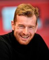 Leverkusen's goalkeeper Lukas Hradecky laughs during an interview with the Associated Press at the BayArena in Leverkusen, Germany, Monday, Dec. 2, 2019. Bayer Leverkusen keeper Lukas Hradecky dislodged a contact lens while playing against the German champions Bayern on Saturday, but he still helped Leverkusen to a surprise win. (AP Photo/Martin Meissner)