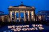 CORRECTS DATE - Activists light candles showing the slogan ' Fight For 1 Point 5' in front of the Brandenburg Gate during a protest of the Fridays For Future movement on the occasion of the fifth anniversary of the signing of the Paris Climate Agreement, in Berlin, Germany, Friday, Dec. 11, 2020. (Britta Pedersen/dpa via AP)