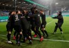 Kiel's players celebrate after beating Bayern Munich during the DFB Cup 2nd round match between Holstein Kiel and Bayern Munich at the Holstein Stadium in Kiel, Germany, Wednesday Jan. 13, 2021. (Christian Charisius/dpa via AP)
