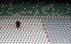 Freiburg's head coach Christian Streich sits in a seat during the German Bundesliga soccer match between SC Freiburg and Borussia Moenchengladbach in Freiburg, Germany, June 5, 2020. Because of the coronavirus outbreak all soccer matches of the German Bundesliga take place without spectators. (Ronald Wittek/Pool via AP)