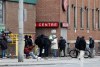 Men gather outside of a shelter in downtown Toronto on Saturday, March 28, 2020. THE CANADIAN PRESS/Colin Perkel