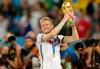 Germany's Andre Schuerrle lifts the trophy after the World Cup final soccer match between Germany and Argentina at the Maracana Stadium in Rio de Janeiro, Brazil, Sunday, July 13, 2014. Former Germany forward André Schürrle has retired aged just 29 after failing to recapture the form that helped him star for Bayer Leverkusen and Chelsea and win the World Cup in 2014. (AP Photo/Frank Augstein)