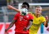 Munich's Alphonso Davies, left, and Dortmund's Erling Haaland, right, challenge for the ball during the German Bundesliga soccer match between Borussia Dortmund and FC Bayern Munich in Dortmund, Germany, Tuesday, May 26, 2020. The German Bundesliga is the world's first major soccer league to resume after a two-month suspension because of the coronavirus pandemic. (Federico Gambarini/DPA via AP, Pool)