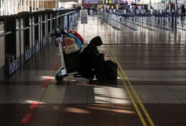 A lone passenger sits near the empty check-in area for Latam airplanes at the Arturo Merino Benitez airport in Santiago, Chile, Tuesday, May 26, 2020. South America’s biggest carrier is seeking U.S. bankruptcy protection as it grapples with a sharp downturn in air travel sparked by the coronavirus pandemic. (AP Photo/Esteban Felix)
