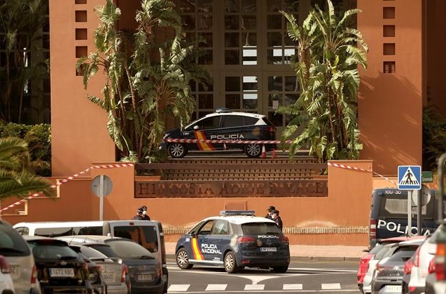 Spanish police officers stand outside the H10 Costa Adeje Palace hotel in Tenerife, Canary Island, Spain, Tuesday, Feb. 25, 2020. Spanish officials say a tourist hotel on the Canary Island hotel of Tenerife has been placed in quarantine after an Italian doctor staying there tested positive for a new virus from China that has infected thousands worldwide. (AP Photo)