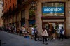 Customers queue outside a sportswear and equipment store during the coronavirus outbreak in Barcelona, Spain, Thursday, June 4, 2020. (AP Photo/Emilio Morenatti)