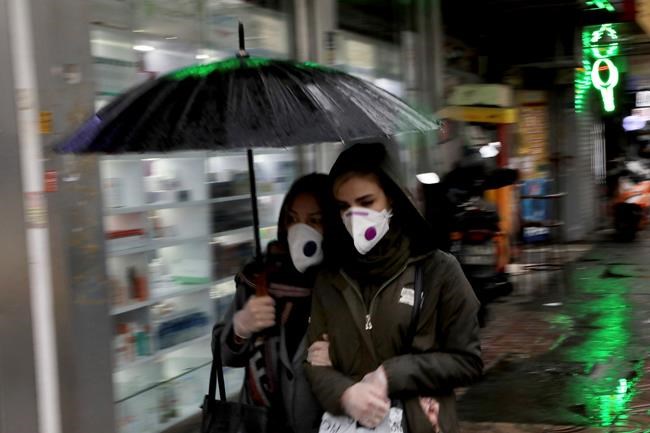 Pedestrians wear masks and gloves to help guard against the Coronavirus in downtown Tehran, Iran, Tuesday, Feb. 25, 2020. The head of Iran's counter-coronavirus task force has tested positive for the virus himself, authorities announced Tuesday, showing the challenges facing the Islamic Republic amid concerns the outbreak may be far wider than officially acknowledged. The announcement comes as countries across the Mideast say they've had confirmed cases of the virus that link back to Iran, which for days denied having the virus. (AP Photo/Ebrahim Noroozi)