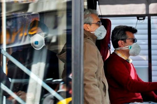 A public bus driver, right, and commuters wear masks to help guard against the Coronavirus in downtown Tehran, Iran, Sunday, Feb. 23, 2020. On Sunday Iran's health ministry raised the death toll from the new virus to 8 people in the country, amid concerns that clusters there, as well as in Italy and South Korea, could signal a serious new stage in its global spread. (AP Photo/Ebrahim Noroozi)