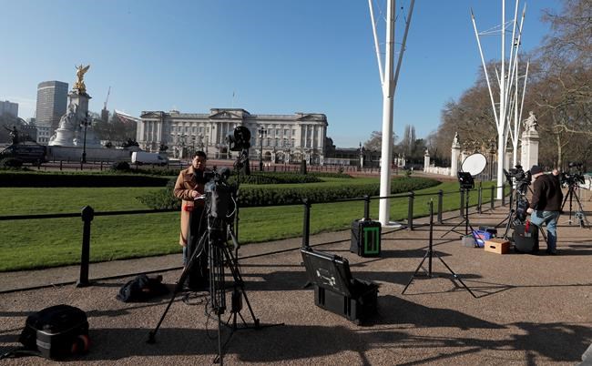 Journalists prepare in front of Buckingham Palace in London, Tuesday, March 9, 2021. Britain's royal family is absorbing the tremors from a sensational television interview by Prince Harry and the Duchess of Sussex, in which the couple said they encountered racist attitudes and a lack of support that drove Meghan to thoughts of suicide. (AP Photo/Frank Augstein)