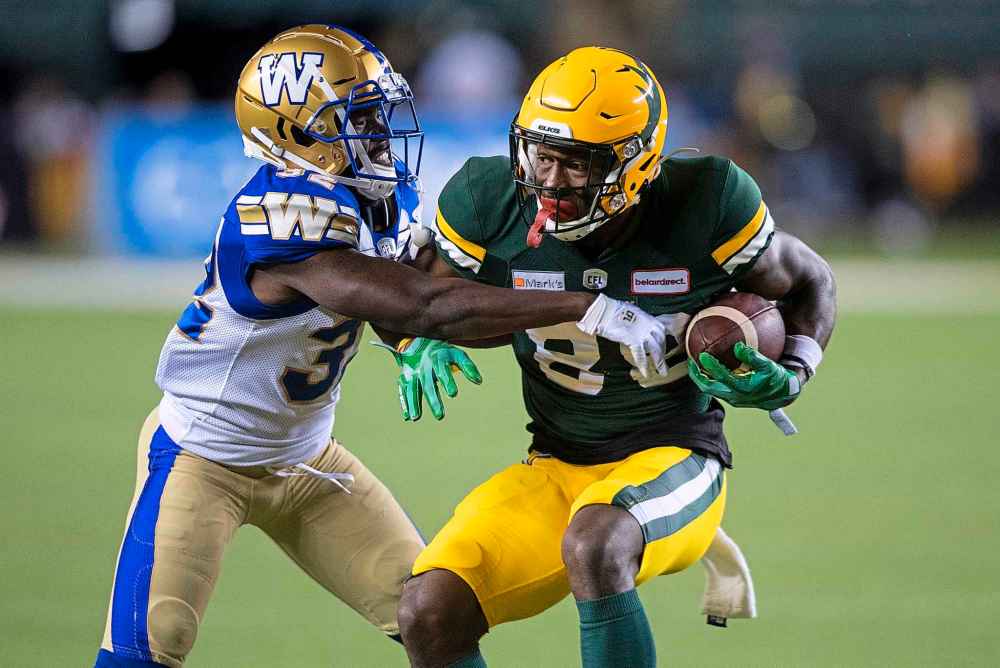 CP
Winnipeg Blue Bombers' Deatrick Nichols (32) tries to tackle Edmonton Elks' Trumaine Washington (8) during the first half. (Jason Franson / The Canadian Press)