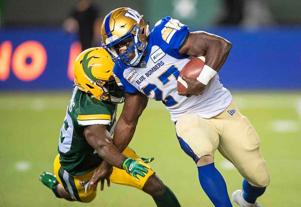 CP
Winnipeg Blue Bombers' Johnny Augustine (27) is tackled by Edmonton Elks' Darius Williams (29) during first half. (Jason Franson / The Canadian Press)