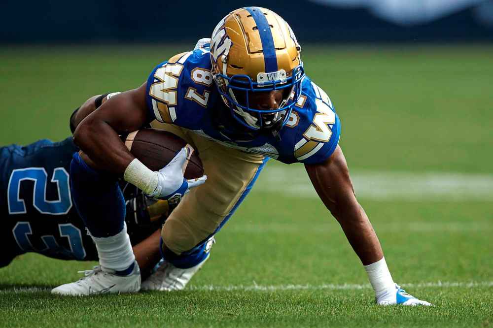 CP
Winnipeg Blue Bombers wide receiver Kelvin McKnight (87) tries to break through a tackle by Toronto Argonauts defensive back Jeff Richards (23) during first half CFL football action. (Cole Burston / The Canadian Press)