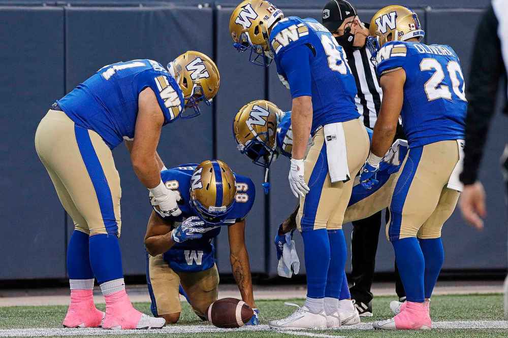 CP
Winnipeg Blue Bombers attend to Kenny Lawler (89) after he caught the touchdown pass and two B.C. Lions players landed on him during the first half. (John Woods / The Canadian Press)