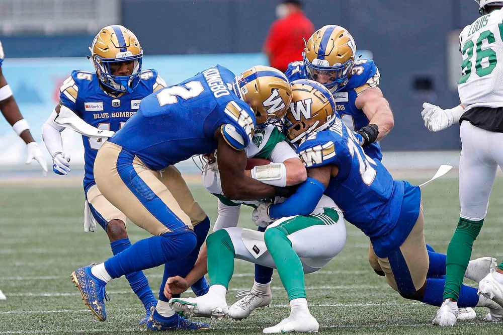 CP
Winnipeg Blue Bombers' Jonathan Kongbo (2) and Alden Darby (22) sack Saskatchewan Roughriders quarterback Isaac Harker (16) during the second half. (John Woods / The Canadian Press)