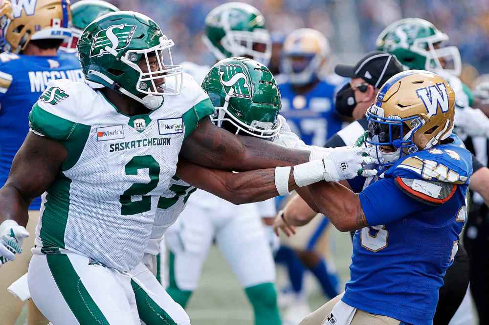 CP
Winnipeg Blue Bombers' Andrew Harris (33) fights with Saskatchewan Roughriders' Micah Johnson (2) and Christian Campbell (38) during first half. (John Woods / The Canadian Press)