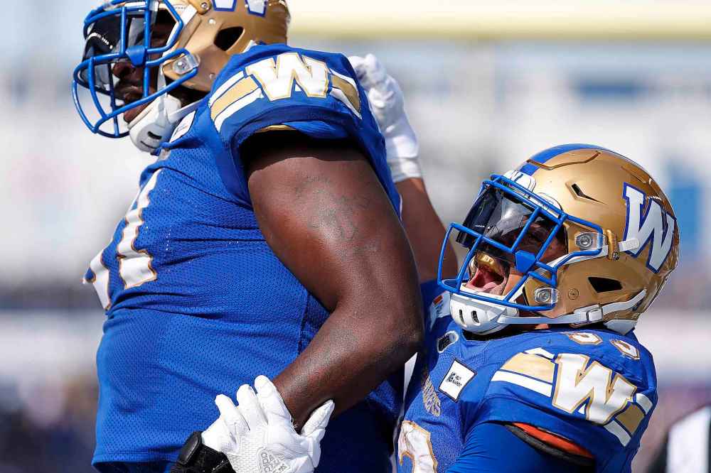 CP
Winnipeg Blue Bombers' Jermarcus Hardrick (51) and Andrew Harris (33) celebrate their touchdown against the Saskatchewan Roughriders during first half. (John Woods / The Canadian Press)