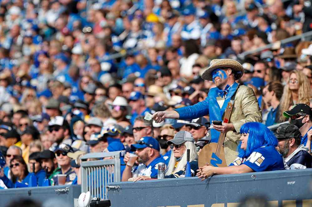 CP
Winnipeg Blue Bombers' fan offers the Saskatchewan Roughriders' bench $20 during first half. (John Woods / The Canadian Press)
