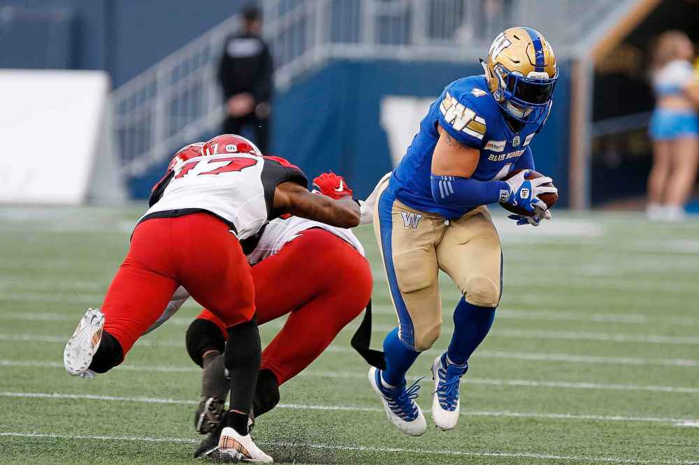 CP
Winnipeg Blue Bombers' Adam Bighill (4) recovers a Calgary Stampeders fumble by Josh Huff (83) during the first half. (John Woods / The Canadian Press)